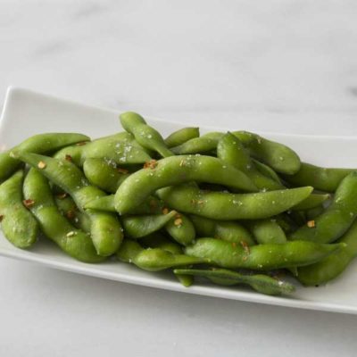 A plate of edamame appetizer; steamed soybeans in the shell tossed with sea salt.