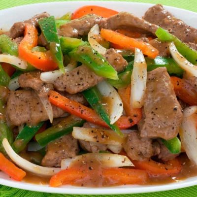 Pepper steak stir fry, pictured with pieces of steak and mixed vegetables in a hearty, spicy pepper sauce.
